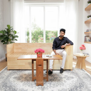 Compact furniture trio including sofa bed, table, and round side table.